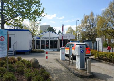 Impfzentrum Moers, Überdachter Eingang, vor dem Eingang steht ein Rettungsdienstwagen