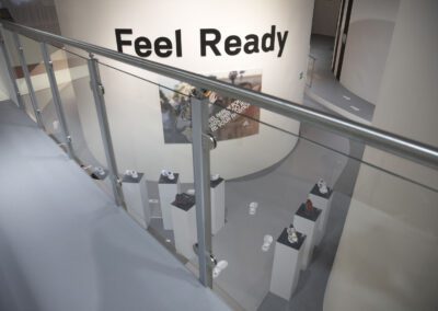 Galerie mit Alu Geländer und Glasfront, mit Blick auf Produktsäulen mit Sportschuhen, in der Mitte große weiße Säule mit 3D Buchstaben und Bild, auf dem Boden „Footprint“ Grafiken