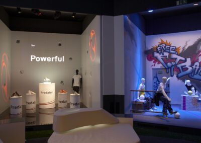 Showroom mit zwei verschiedenen Ausstellungsständen, einer im Storedesign und beleuchteten Produktsäulen, einer im Graffiti Urban Look mit sportlichen Schaufensterpuppen